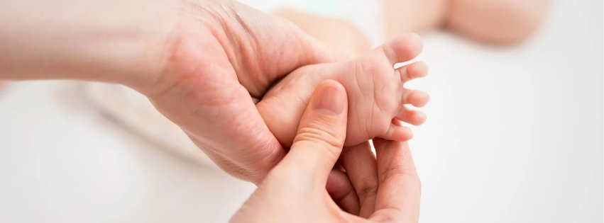 Vyöhyketerapia - vauvan jalkaa hierotaan hellästi